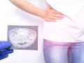 Lekarz w rękawiczce pokazuje tomografię jamy brzusznej osobie z bólem brzucha.