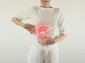Kobieta w białej koszulce i spodniach trzyma się za brzuch, na którym widnieje rysunek wątroby z czerwonym podświetleniem.