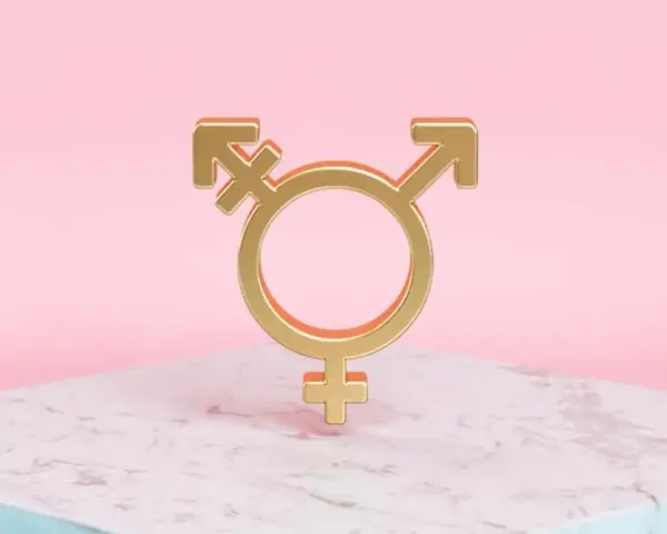 Złoty symbol trans, łączący symbole Wenus, Marsa i hermafrodyty, na marmurowej podstawie.